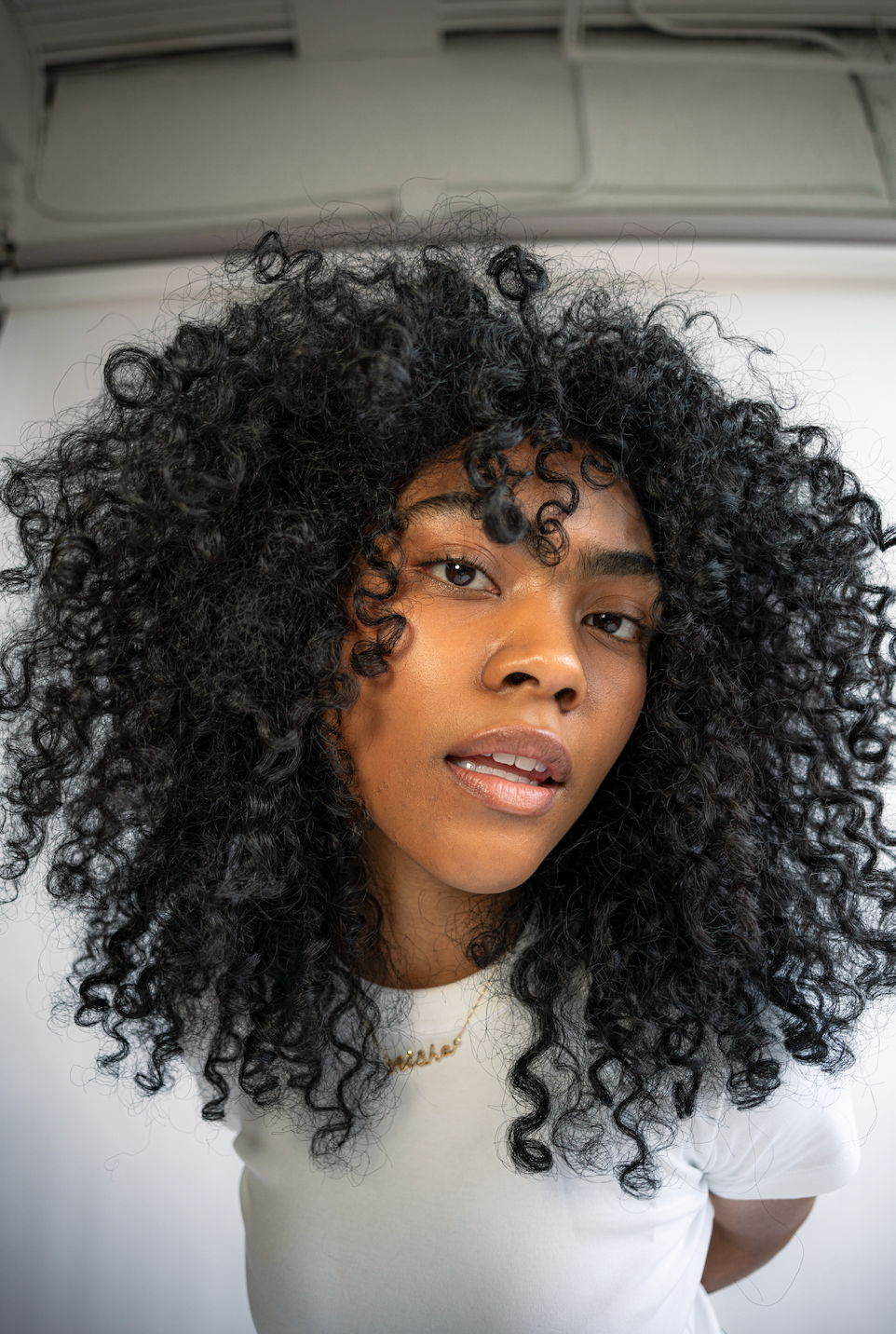 Close up of a woman showcasing her healthy curly hair.