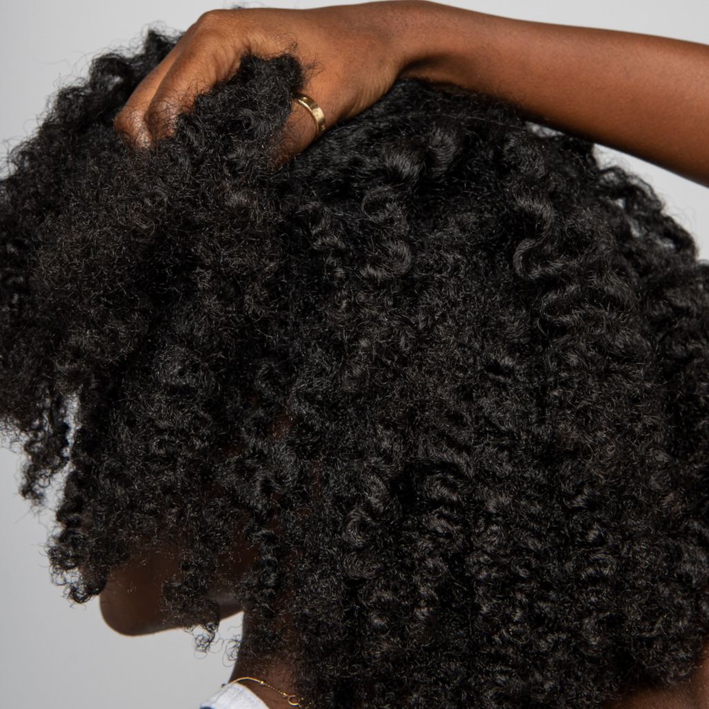 Close up of a woman with 4b curly hair.